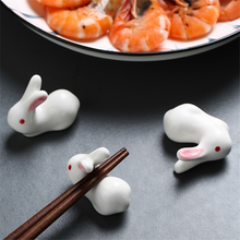Load image into Gallery viewer, Enhance your Asian dining experience with our Ceramic Rabbit Chopstick Rests by Allthingscurated. These pieces will bring a playful edge to your table with their ability to keep your chopsticks clean and secure. Comes in a set of 3 or 6 pieces.
