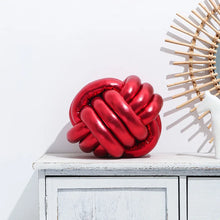Load image into Gallery viewer, Metallic Color Knot Ball Cushions by Allthingscurated come in a metallic palette of Gold, Silver and Red. These cushions will give your home a trendy update easily with their bold design and bring attention to your favorite sofa or chair. Their unique spherical shape and eye-catching colors will add a stylish and sculptural touch to your living space.