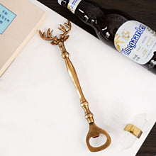 Load image into Gallery viewer, Brass Reindeer Bottle Opener by Allthingscurated. Crafted from brass and designed with a long handle and an ornamental reindeer head—it is an eye-catching bar tool and charming accessory for Christmas and beyond.