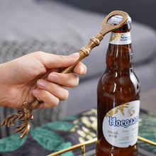 Load image into Gallery viewer, Brass Reindeer Bottle Opener by Allthingscurated. Crafted from brass and designed with a long handle and an ornamental reindeer head—it is an eye-catching bar tool and charming accessory for Christmas and beyond.