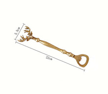 Load image into Gallery viewer, Brass Reindeer Bottle Opener by Allthingscurated. Crafted from brass and designed with a long handle and an ornamental reindeer head—it is an eye-catching bar tool and charming accessory for Christmas and beyond.