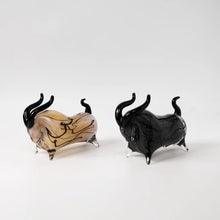 Load image into Gallery viewer, Two glass bull figurines, one two tone and one black on a white background. Rex Decorative Bull by Allthingscurated are meticulously handmade from high quality glass. Comes in three striking finishes—an all-all black edition or two-tone variants featuring bold graphic elements. Rex brings contemporary flair and bold energy to any room. More than décor, it’s an ideal gift for those born under the Ox zodiac and Taurus sign.