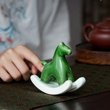 Load image into Gallery viewer, This Petite Ceramic Rocking Horse by Allthingscurated is a work of art. Crafted by hand from ceramic and decorated with a beautiful crackle pattern, it exudes a subtle far-eastern beauty and grace. Makes a perfect gift for those who appreciate quality craftsmanship and a treasured gift to any horse collector. Comes in green and azurerish white. Measures 9.8cm or 3.8 inches in height, 10.4cm or 4 inches in width and 4.2cm or 1.6 inches in depth.