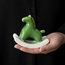 Load image into Gallery viewer, This Petite Ceramic Rocking Horse by Allthingscurated is a work of art. Crafted by hand from ceramic and decorated with a beautiful crackle pattern, it exudes a subtle far-eastern beauty and grace. Makes a perfect gift for those who appreciate quality craftsmanship and a treasured gift to any horse collector. Comes in green and azurerish white. Measures 9.8cm or 3.8 inches in height, 10.4cm or 4 inches in width and 4.2cm or 1.6 inches in depth.
