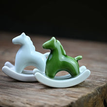 Load image into Gallery viewer, This Petite Ceramic Rocking Horse by Allthingscurated is a work of art. Crafted by hand from ceramic and decorated with a beautiful crackle pattern, it exudes a subtle far-eastern beauty and grace. Makes a perfect gift for those who appreciate quality craftsmanship and a treasured gift to any horse collector. Comes in green and azurerish white. Measures 9.8cm or 3.8 inches in height, 10.4cm or 4 inches in width and 4.2cm or 1.6 inches in depth.