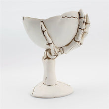 Load image into Gallery viewer, Gothic Skeleton Hand Storage Bowl by Allthingscurated boasts a spooky design featuring a ghoulish skeleton claw in neutral warm off-white and vivid hand bones encircling the bowl. Perfect for adding a frightful touch to your Halloween decor. Crafted from resin and measuring height of 13.5m or5.3 inches and width of 12cm or 4.7 inches.