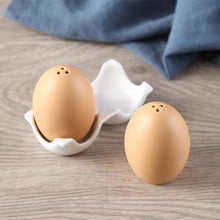 Load image into Gallery viewer, Brown Egg Salt Pepper Shaker Set by Allthingscurated are made of high-quality ceramic and designed to resemble real eggs. These shakers come with a try to securely hold them in place. Perfect for your Easter table or as a thoughtful housewarming gift.