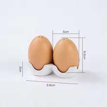 Load image into Gallery viewer, Brown Egg Salt Pepper Shaker Set by Allthingscurated are made of high-quality ceramic and designed to resemble real eggs. These shakers come with a try to securely hold them in place. Perfect for your Easter table or as a thoughtful housewarming gift.
