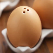 Load image into Gallery viewer, Brown Egg Salt Pepper Shaker Set by Allthingscurated are made of high-quality ceramic and designed to resemble real eggs. These shakers come with a try to securely hold them in place. Perfect for your Easter table or as a thoughtful housewarming gift.