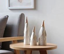 Load image into Gallery viewer, Not your typical jolly Santa Clauses with a plush red suit and rounded belly, this Nordic Santa Claus Figurines Set by Allthingscurated featured 3 porcelain figures of Santa Claus dressed in long white gown and a gold pointed hat. With subtle, understated elegance, they are perfect decoration to add to your Christmas collection to create an enchanting display. Figurines come in 3 different heights of 15cm, 20cm and 23cm or 6 inches, 7.8 inches and 9 inches.