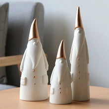 Load image into Gallery viewer, Not your typical jolly Santa Clauses with a plush red suit and rounded belly, this Nordic Santa Claus Figurines Set by Allthingscurated featured 3 porcelain figures of Santa Claus dressed in long white gown and a gold pointed hat. With subtle, understated elegance, they are perfect decoration to add to your Christmas collection to create an enchanting display. Figurines come in 3 different heights of 15cm, 20cm and 23cm or 6 inches, 7.8 inches and 9 inches.