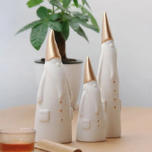 Load image into Gallery viewer, Not your typical jolly Santa Clauses with a plush red suit and rounded belly, this Nordic Santa Claus Figurines Set by Allthingscurated featured 3 porcelain figures of Santa Claus dressed in long white gown and a gold pointed hat. With subtle, understated elegance, they are perfect decoration to add to your Christmas collection to create an enchanting display. Figurines come in 3 different heights of 15cm, 20cm and 23cm or 6 inches, 7.8 inches and 9 inches.