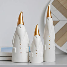 Load image into Gallery viewer, Not your typical jolly Santa Clauses with a plush red suit and rounded belly, this Nordic Santa Claus Figurines Set by Allthingscurated featured 3 porcelain figures of Santa Claus dressed in long white gown and a gold pointed hat. With subtle, understated elegance, they are perfect decoration to add to your Christmas collection to create an enchanting display. Figurines come in 3 different heights of 15cm, 20cm and 23cm or 6 inches, 7.8 inches and 9 inches.