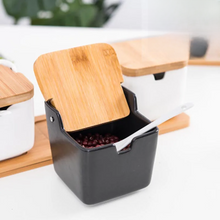 Load image into Gallery viewer, Ceramic Seasoning Storage Jars by Allthingscurated are the perfect storage solution to keep your herbs, seasonings and spices. Made of durable ceramic with a sustainable bamboo flip lid for easy access during cooking. These jars are not only functional but also environmentally friendly. Comes with a bamboo tray and ceramic spoons.