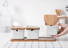 Load image into Gallery viewer, Ceramic Seasoning Storage Jars by Allthingscurated are the perfect storage solution to keep your herbs, seasonings and spices. Made of durable ceramic with a sustainable bamboo flip lid for easy access during cooking. These jars are not only functional but also environmentally friendly. Comes with a bamboo tray and ceramic spoons.