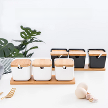 Load image into Gallery viewer, Ceramic Seasoning Storage Jars by Allthingscurated are the perfect storage solution to keep your herbs, seasonings and spices. Made of durable ceramic with a sustainable bamboo flip lid for easy access during cooking. These jars are not only functional but also environmentally friendly. Comes with a bamboo tray and ceramic spoons.