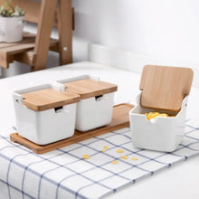 Load image into Gallery viewer, Ceramic Seasoning Storage Jars by Allthingscurated are the perfect storage solution to keep your herbs, seasonings and spices. Made of durable ceramic with a sustainable bamboo flip lid for easy access during cooking. These jars are not only functional but also environmentally friendly. Comes with a bamboo tray and ceramic spoons.