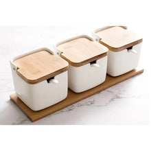 Load image into Gallery viewer, Ceramic Seasoning Storage Jars by Allthingscurated are the perfect storage solution to keep your herbs, seasonings and spices. Made of durable ceramic with a sustainable bamboo flip lid for easy access during cooking. These jars are not only functional but also environmentally friendly. Comes with a bamboo tray and ceramic spoons.