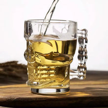 Load image into Gallery viewer, Skull Beer Mug by Allthingscurated blends functionality with style. Made with thickened glass with a heavy bottom for stability, it spots a fun, cool skull shape design that is ideal for Halloween or everyday use. The large capacity is perfect for beer or any beverage. Add this must-have mug to your drinkware collection and be ready for any gatherings or house parties.