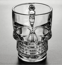 Load image into Gallery viewer, Skull Beer Mug by Allthingscurated blends functionality with style. Made with thickened glass with a heavy bottom for stability, it spots a fun, cool skull shape design that is ideal for Halloween or everyday use. The large capacity is perfect for beer or any beverage. Add this must-have mug to your drinkware collection and be ready for any gatherings or house parties.