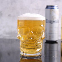 Load image into Gallery viewer, Skull Beer Mug by Allthingscurated blends functionality with style. Made with thickened glass with a heavy bottom for stability, it spots a fun, cool skull shape design that is ideal for Halloween or everyday use. The large capacity is perfect for beer or any beverage. Add this must-have mug to your drinkware collection and be ready for any gatherings or house parties.