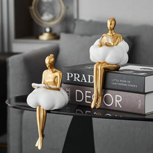 Load image into Gallery viewer, Sophie Cloud Girl Sculptures by Allthingscurated feature 2 beautiful lady statues in 2 postures—reading and pondering. Adorned with a classic ballerina bun and dressed in a minimalistic dress that ends with a voluminous skirt reminiscent of fluffy clouds. These sculptures bring a touch of serenity and sophistication to your living space.