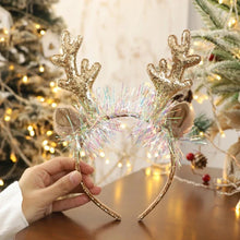 Load image into Gallery viewer, Add some sparkle to your holiday party with these Glittering Antler Christmas Headbands by Allthingscurated. Comes in 2 designs in Red or Gold. These beautiful accessories are perfect for hyping up the festive atmosphere. Featured here is the Gold Antler headband embellished with tinsel.