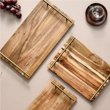 Load image into Gallery viewer, Wooden Serving Tray by Allthingscurated is designed with versatility and organic beauty in mind. Crafted from natural wood and accented with gold hardware handles for easy transportation and handling, these wooden trays serve up your sliced breads, cheeses and drinks in style. With 3 size options, they are ideal for hosting and a nice presentation with a natural touch to your table.