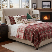 Load image into Gallery viewer, Cozy bedroom with a bed covered in plaid blankets and pillows, near a fireplace. Elevate your seasonal décor with this curated selection of holiday Decorative Christmas Pillows and Covers Collection by Allthingscurated. Sewn from quality, soft fabrics with thoughtful tufted details, each piece delivers both comfort and visual appeal to your home.