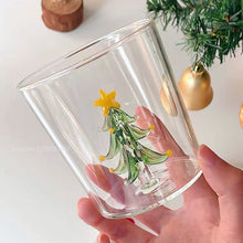 Load image into Gallery viewer, Christmas Tree Drinking Glass by Allthingscurated has a playful and whimsical design, featuring a sculptural 3D Christmas Tree within the tumbler. The tree comes in a 2 colors, green and white. Measuring 8.5cm or 3.3 inches in width at the top, 9cm or 3.5 inches in height and 6.5cm or 2.5 inches in width at the base, the drinking glass has a capacity of 300ml or 10 ounce. Featured here is one with a green Christmas Tree.