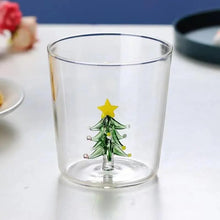 Load image into Gallery viewer, Christmas Tree Drinking Glass by Allthingscurated has a playful and whimsical design, featuring a sculptural 3D Christmas Tree within the tumbler. The tree comes in a 2 colors, green and white. Measuring 8.5cm or 3.3 inches in width at the top, 9cm or 3.5 inches in height and 6.5cm or 2.5 inches in width at the base, the drinking glass has a capacity of 300ml or 10 ounce. Featured here is one with a green Christmas tree.