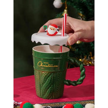 Load image into Gallery viewer, Snow Capped Christmas Gift Mug by Allthingscurated boasts festive colors of red, green and white, featuring a Merry Christmas greeting engraved on the mug. The elegant mug is crafted from ceramic with a snow-like lid and a charming Christmas relief pattern, making it the perfect gift for your friends and colleagues during office parties. Comes with a straw for added convenience.