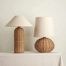 Load image into Gallery viewer, Two rattan table lamps with beige lampshades on a light surface. The Yumi Japanese Table Lamp by Allthingscurated embraces the wabi-sabi philosophy that profound beauty emerges from simplicity. Crafted from natural rattan, its minimalist design feels both rustic and contemporary. It elevates your home décor by transforming any space into a sanctuary of quiet sophistication.