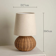 Load image into Gallery viewer, Short rattan table lamp shown with dimensions on a neutral background. The Yumi Japanese Table Lamp by Allthingscurated embraces the wabi-sabi philosophy that profound beauty emerges from simplicity. Crafted from natural rattan, its minimalist design feels both rustic and contemporary. It elevates your home décor by transforming any space into a sanctuary of quiet sophistication.