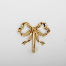 Load image into Gallery viewer, These pretty wall hooks by Allthingscurated are made of high-quality brass with a vintage gold finish.  Fashioned like a bow tied with ribbon, it’s feminine and perfect for the walk-in wardrobe or powder room. Comes in small and large size. Small hook measures 7.3cm or 2.8 inches in height and 6.5cm or 2.5 inches in width. Large hook measures 10.3cm or 4 inches in height and 9.5cm or 3.7 inches in width. Sold as individual hooks or a set of small and large hooks. This is a large hook.