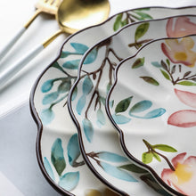 Load image into Gallery viewer, Allthingscurated’s Camille dinnerware features hand-painted florals, fauna and pretty butterflies and a color scheme of pink, yellow, blue,green and brown against a white ceramic background. Every plate is designed with a brown-lined scallop edge. Available in 6, 8 and 10 inches or 15.5, 20 and 25.5cm.