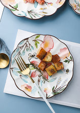 Load image into Gallery viewer, Allthingscurated’s Camille dinnerware features hand-painted florals, fauna and pretty butterflies and a color scheme of pink, yellow, blue,green and brown against a white ceramic background. Every plate is designed with a brown-lined scallop edge. Available in 6, 8 and 10 inches or 15.5, 20 and 25.5cm.