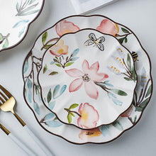 Load image into Gallery viewer, Allthingscurated’s Camille dinnerware features hand-painted florals, fauna and pretty butterflies and a color scheme of pink, yellow, blue,green and brown against a white ceramic background. Every plate is designed with a brown-lined scallop edge. Available in 6, 8 and 10 inches or 15.5, 20 and 25.5cm.