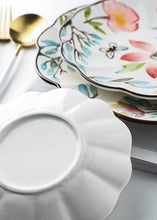 Load image into Gallery viewer, Allthingscurated’s Camille dinnerware features hand-painted florals, fauna and pretty butterflies and a color scheme of pink, yellow, blue,green and brown against a white ceramic background. Every plate is designed with a brown-lined scallop edge. Available in 6, 8 and 10 inches or 15.5, 20 and 25.5cm.
