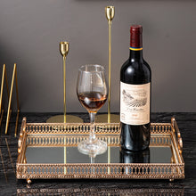 Load image into Gallery viewer, Donatella Mirror tray by Allthingscurated features a mirror surface and intricate gold-gilded pattern surround all sides of the rectangle tray and with 2 handles. Available in small, medium and large size. Featured here is a large tray wit h a bottle of red wine and a red wine glass.