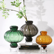Load image into Gallery viewer, Luna Lantern Vases by Allthingscurated are stylish and versatile. Crafted from high-quality thick glass and creatively shaped like an Oriental Lantern with a strong aesthetic, they are perfect for creative floral arrangement or simply as a decorative display on its own. Comes in 2 sizes and 3 avaliable colors of green, gray and amber.