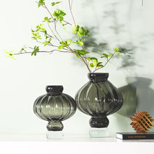 Load image into Gallery viewer, Luna Lantern Vases by Allthingscurated are stylish and versatile. Crafted from high-quality thick glass and creatively shaped like an Oriental Lantern with a strong aesthetic, they are perfect for creative floral arrangement or simply as a decorative display on its own. Comes in 2 sizes and 3 avaliable colors of green, gray and amber.
