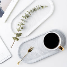 Load image into Gallery viewer, Allthingscurated Marble Design Oval Ceramic Trays in White with subtle marble veining. These trays can be used for serving and decorative purposes. Available in Small and Large size. Large tray measuring 32 by 15 centimeters or 12.5 by 5.9 inches. Small tray measures 25.5 by 11.8 centimeters or 10 by 4.6 inches.