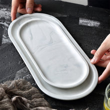 Load image into Gallery viewer, Allthingscurated Marble Design Oval Ceramic Trays in White with subtle marble veining. These trays can be used for serving and decorative purposes. Available in Small and Large size. Large tray measuring 32 by 15 centimeters or 12.5 by 5.9 inches. Small tray measures 25.5 by 11.8 centimeters or 10 by 4.6 inches.