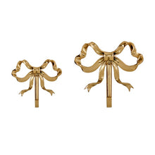 Load image into Gallery viewer, These pretty wall hooks by Allthingscurated are made of high-quality brass with a vintage gold finish.  Fashioned like a bow tied with ribbon, it’s feminine and perfect for the walk-in wardrobe or powder room. Comes in small and large size. Small hook measures 7.3cm or 2.8 inches in height and 6.5cm or 2.5 inches in width. Large hook measures 10.3cm or 4 inches in height and 9.5cm or 3.7 inches in width. Sold as individual hooks or a set of small and large hooks. This is a set of 2 hooks.