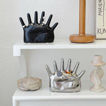 Load image into Gallery viewer, This abstract, one-of-a-kind contemporary jewelry holder by Allthingscurated is designed as an upright-standing palm with 6 fingers for slotting your favorite rings, bracelets or bangles. Made of ceramic and available in silver and black. It measures 19cm or 7.4 inches in width, 16cm or 6.2 inches in height and 14.5cm or 5.7 inches in depth.