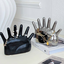Load image into Gallery viewer, This abstract, one-of-a-kind contemporary jewelry holder by Allthingscurated is designed as an upright-standing palm with 6 fingers for slotting your favorite rings, bracelets or bangles. Made of ceramic and available in silver and black. It measures 19cm or 7.4 inches in width, 16cm or 6.2 inches in height and 14.5cm or 5.7 inches in depth.