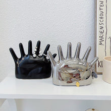 Load image into Gallery viewer, This abstract, one-of-a-kind contemporary jewelry holder by Allthingscurated is designed as an upright-standing palm with 6 fingers for slotting your favorite rings, bracelets or bangles. Made of ceramic and available in silver and black. It measures 19cm or 7.4 inches in width, 16cm or 6.2 inches in height and 14.5cm or 5.7 inches in depth.