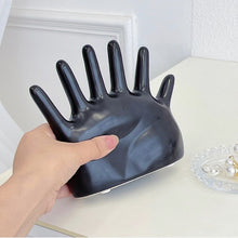 Load image into Gallery viewer, This abstract, one-of-a-kind contemporary jewelry holder by Allthingscurated is designed as an upright-standing palm with 6 fingers for slotting your favorite rings, bracelets or bangles. Made of ceramic and available in silver and black. It measures 19cm or 7.4 inches in width, 16cm or 6.2 inches in height and 14.5cm or 5.7 inches in depth.