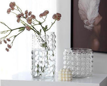 Load image into Gallery viewer, Zayla Bubble Vase by Allthingscurated features a geometric bubble design. The eye-catching detail and design are enough to make it a statement centerpiece with or without floral display. Comes in black or clear and in 2 sizes. The short vase measures 17cm or 6.6 inches in height and 16cm or 6.2 inches in diameter. The tall vase measures 27.5cm or 10.7 inches in height and 13cm or 5 inches in diameter. This is a pair of clear vases with small pink flowers in the tall vase.